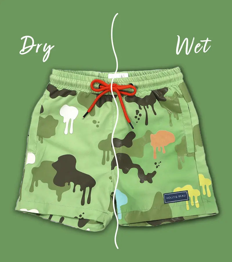Holly and Beau Colour changing Green swim shorts with Camouflage print and Orange drawstring on a green background showing the dry and sides