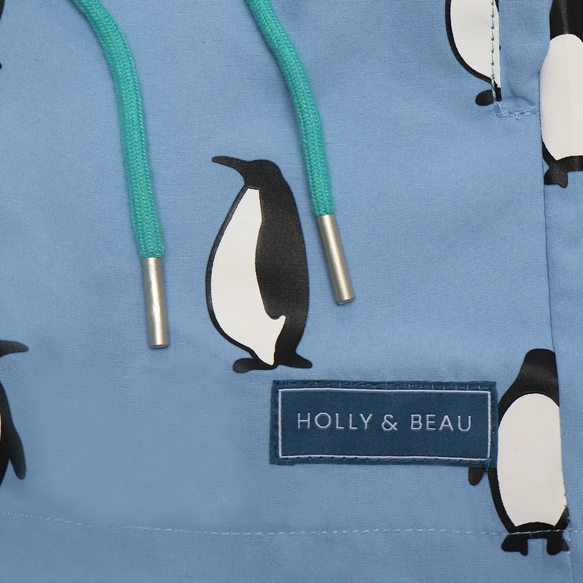 Holly and Beau light blue penguin boys colour changing swim shorts. Front drawstring and logo