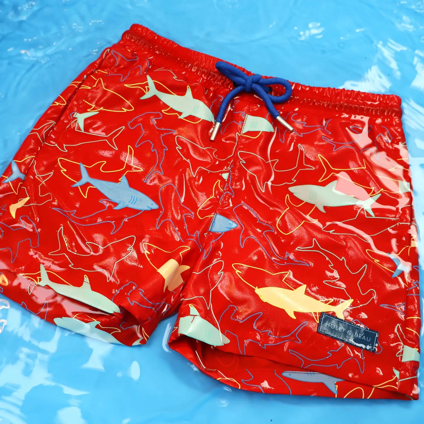 Holly and Beau Red sharks boys colour changing swim shorts in the water after colour change