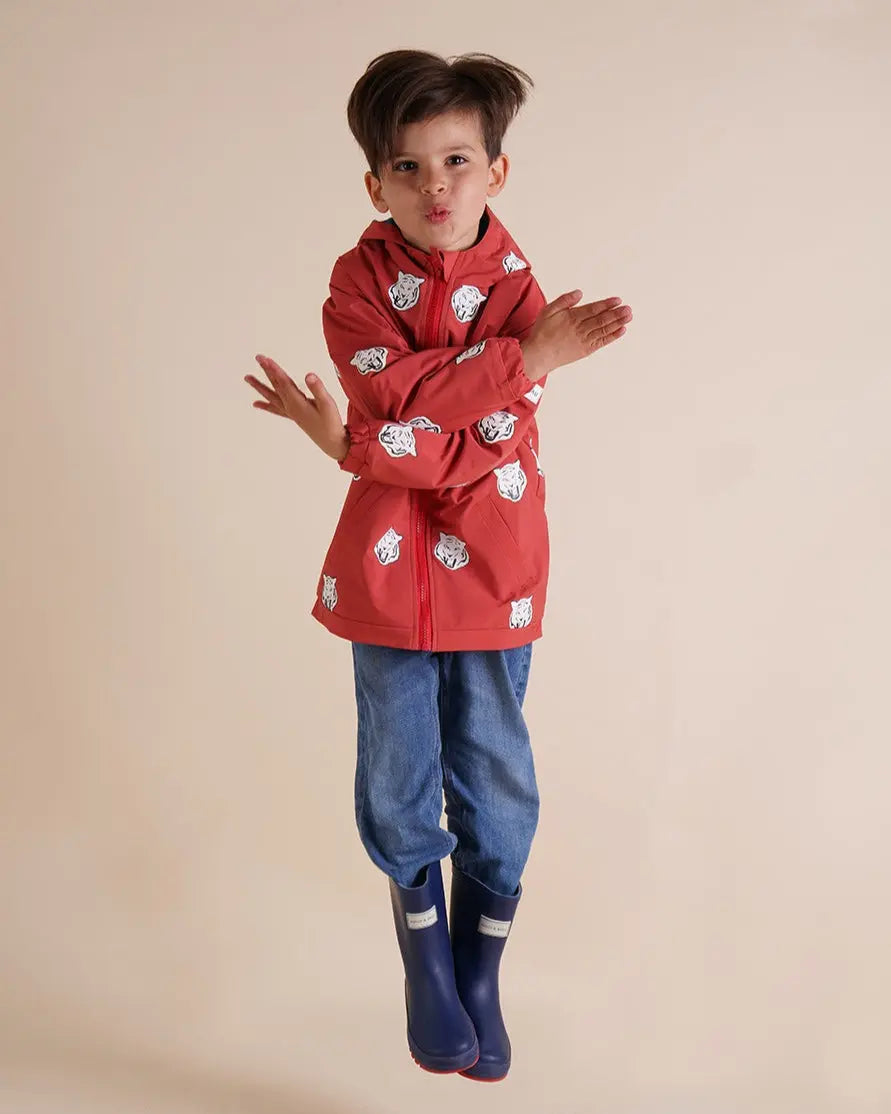 Holly and Beau jumping boy wearing red tiger colour changing raincoat