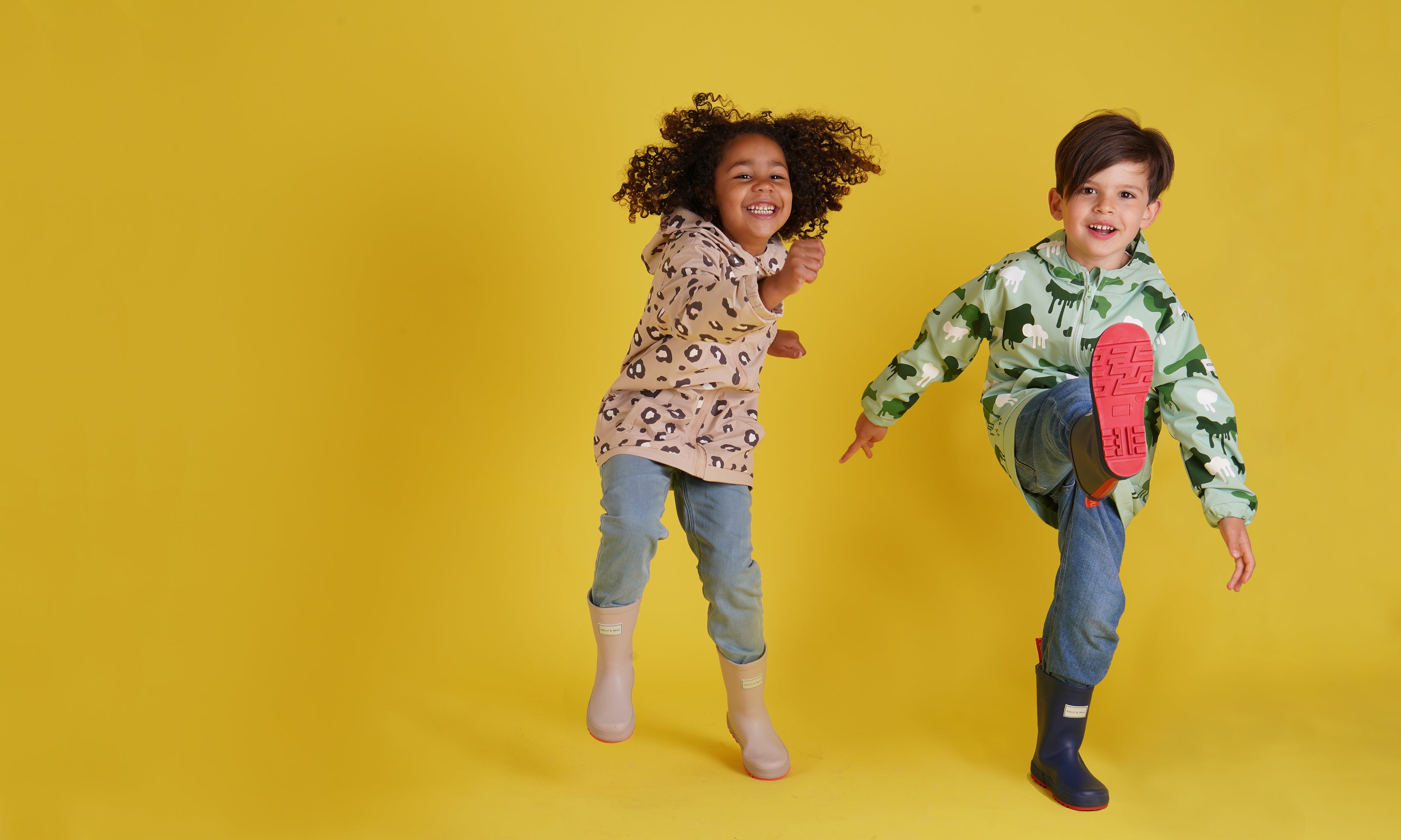 Holly and Beau - happy kids wearing their colour changing raincoats ready for outdoor adventures