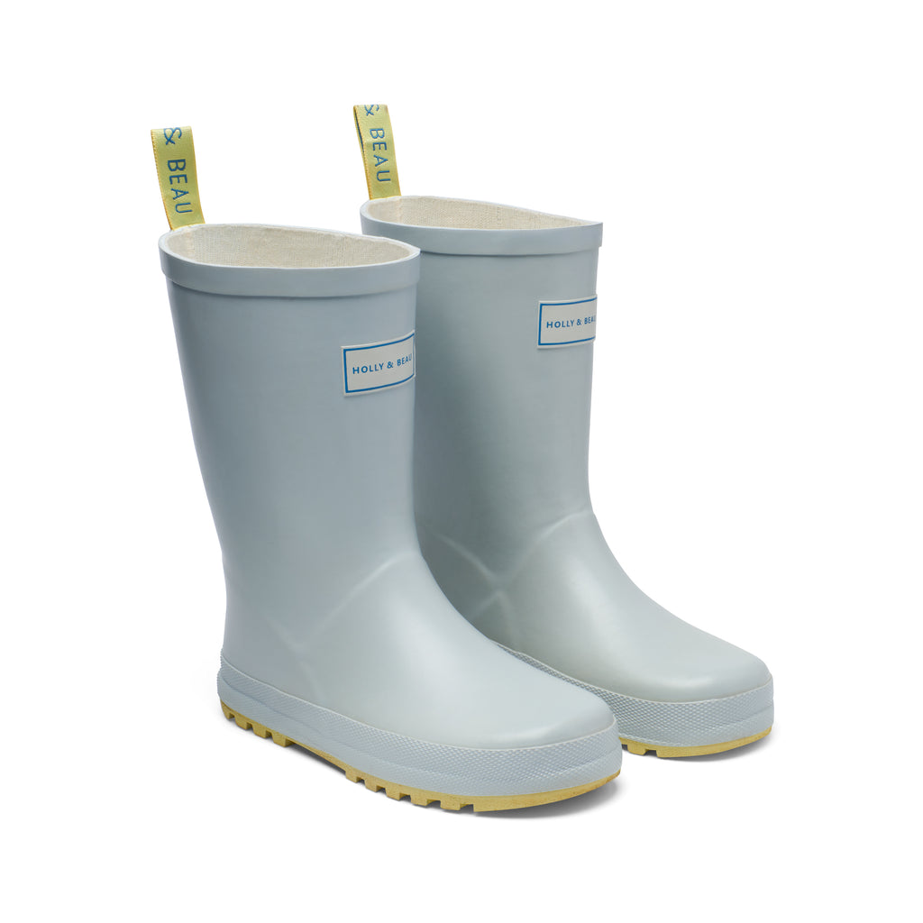 Light blue and yellow rubber girls wellies by rainwear brand Holly and Beau. Made from natural rubber, ideal for rainy days and muddy puddles. A great gift for a little boy and a little girl